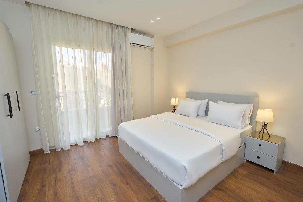 Una cama o camas en una habitación de Settle Inn Banafseg Apartments