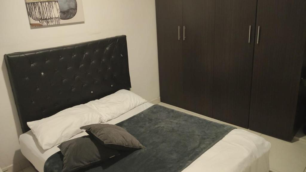 a bed with a black headboard in a bedroom at 2 Habitaciones 2Aires Reservas SL in Cúcuta