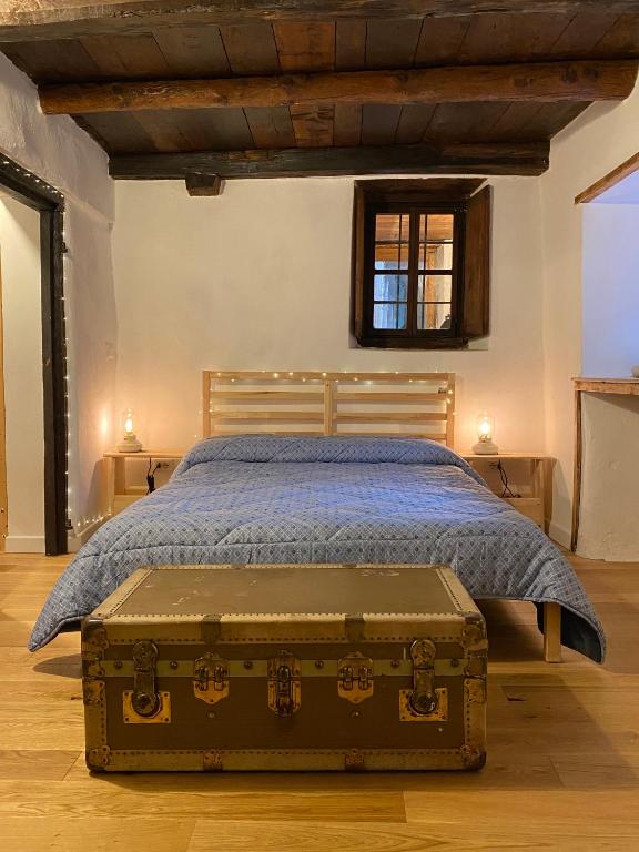 a bedroom with a bed with a trunk on the floor at La Casetta in Bannio