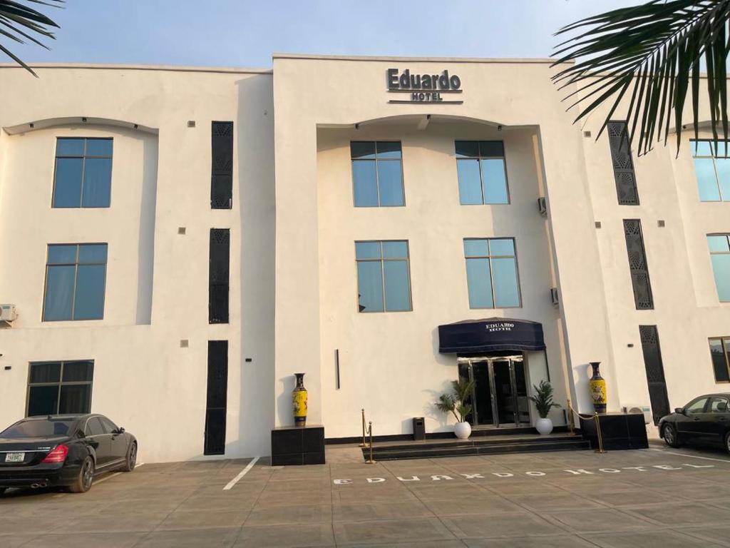 a building with a car parked in front of it at Eduardo Hotel in Dushekoro