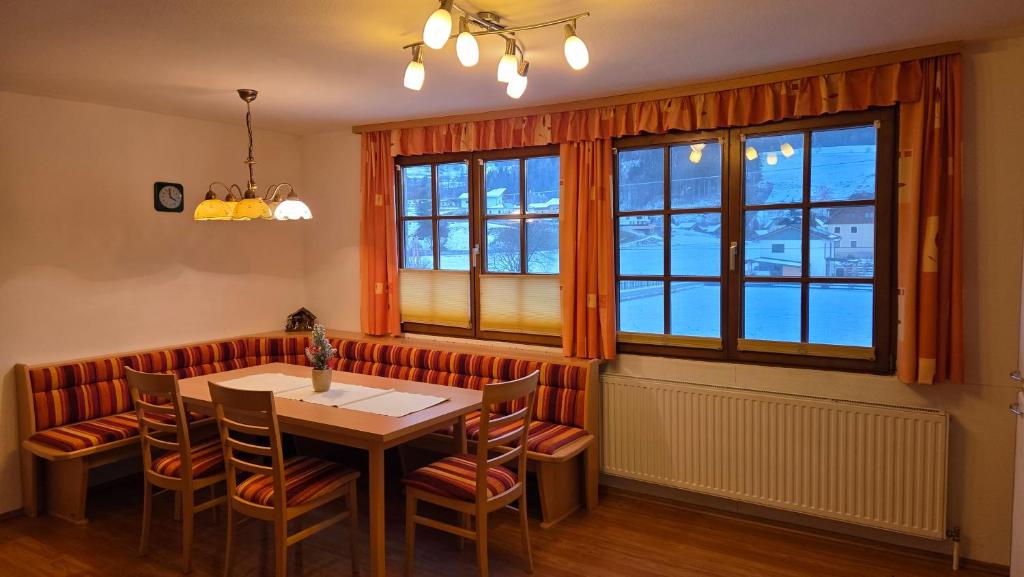 a dining room with a table and chairs and a window at Zettler Apartment in Großsölk