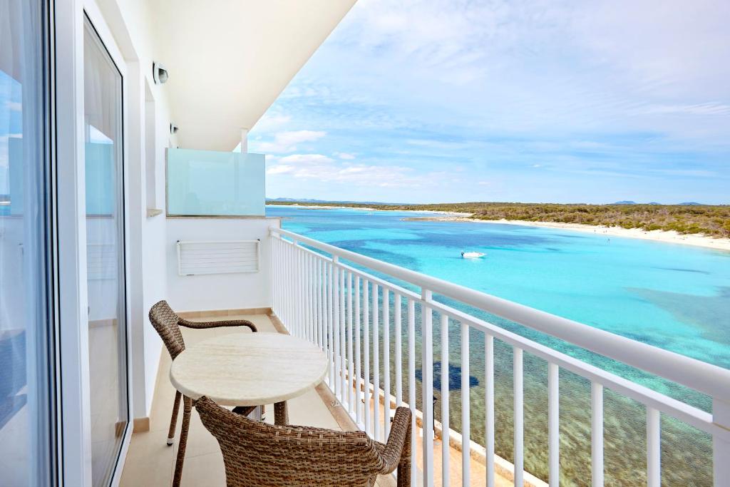 a balcony with a table and chairs and the ocean at Universal Hotel Marqués in Colònia de Sant Jordi