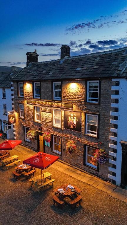 a building with tables and umbrellas in front of it at The Kings Arms Hotel in Reeth