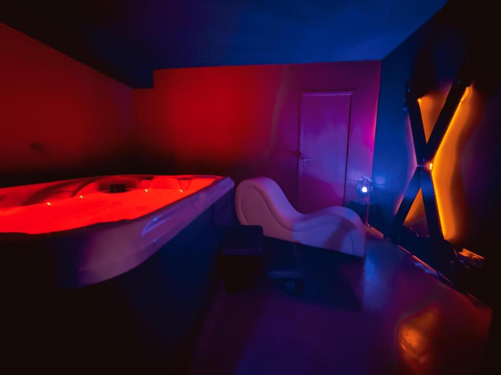 een kamer met rode en blauwe lichten en een bad bij Love Room L Interlude in Vitrolles