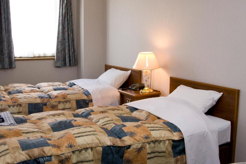 Postel nebo postele na pokoji v ubytování Shinseto Station Hotel