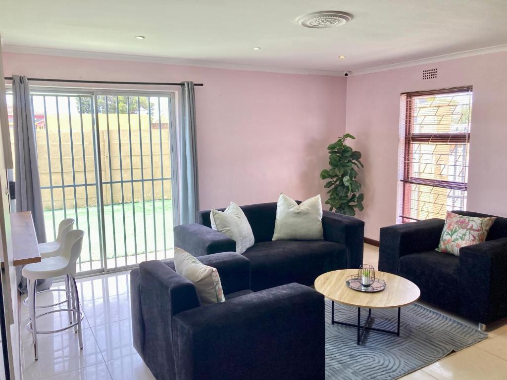 BelharUnit 1 GatherPoint Sleeps 6 Self-Catering Group in Belhar, Cape Town的带沙发、椅子和桌子的客厅