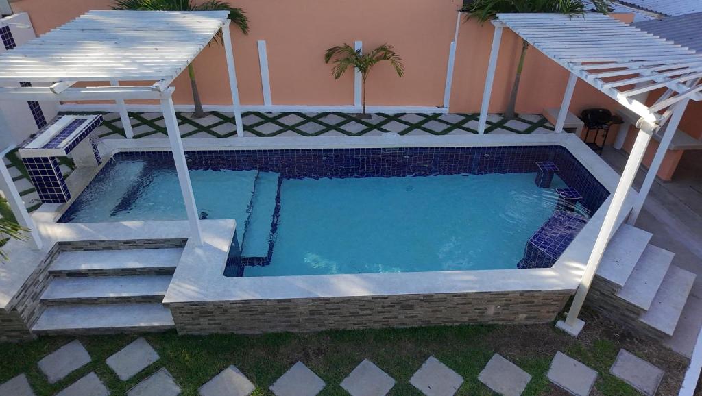a swimming pool with stairs leading to a house at Costabay in El Zapote