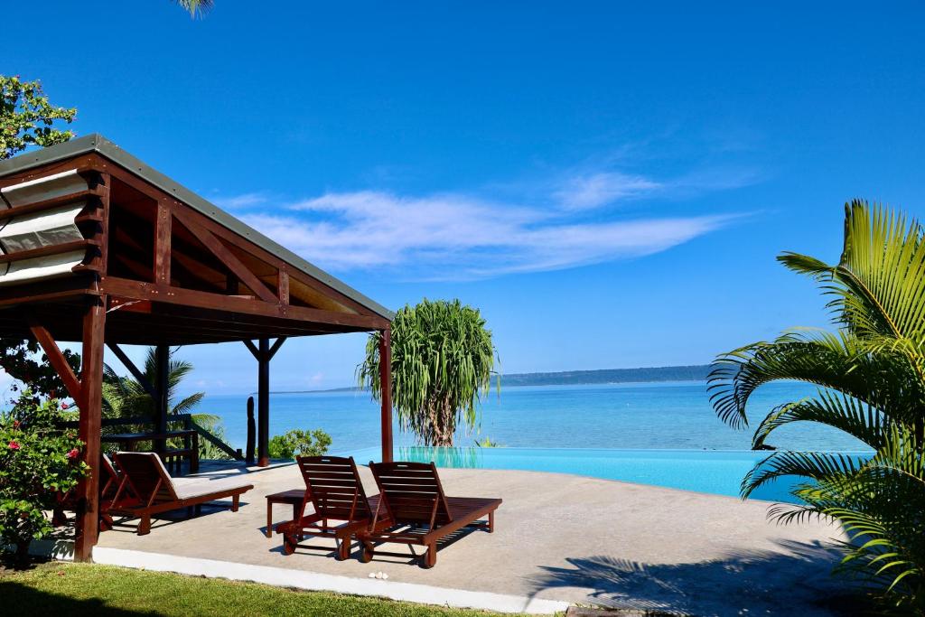 a group of chairs sitting next to a swimming pool at The Namele Villas in Port Vila