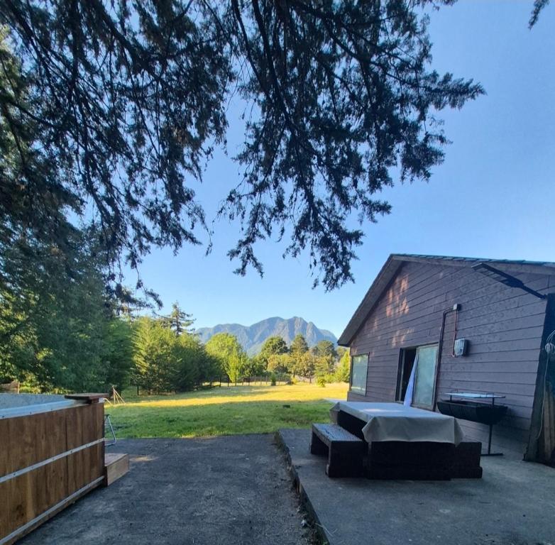 Un patio trasero con una casa y un banco y un edificio. en Lodge Dream Pucon, en Pucón