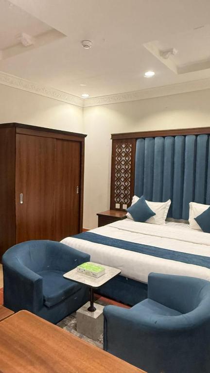 a hotel room with a bed and a chair at Distinctive Palace - القصصر المميز للشقق المفروشه in Abha