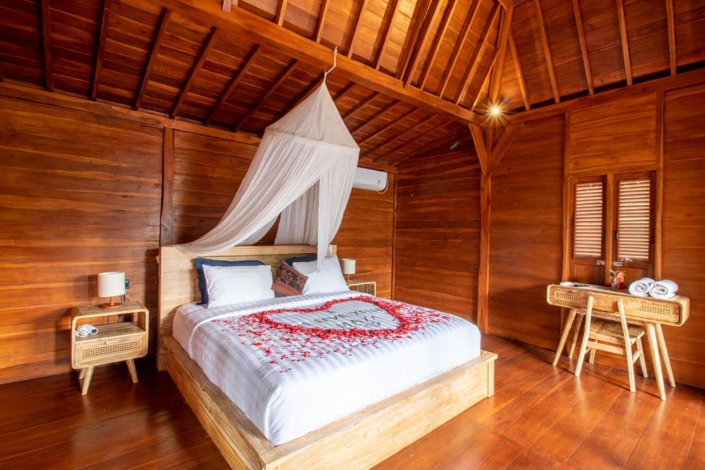a bedroom with a canopy bed in a wooden room at Langkih Private Villas in Tegalalang