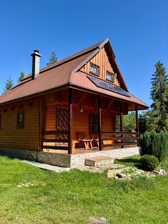 a large wooden cabin with a picnic table in front of it at Chata MOBY in Važec