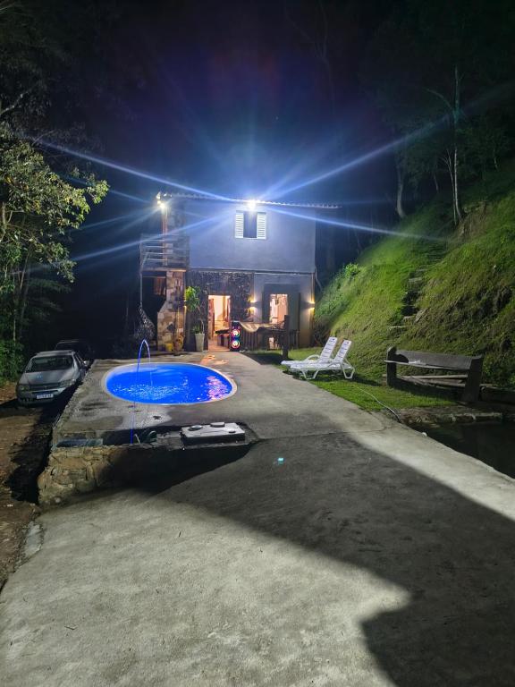 una casa con piscina di notte di Chalé Foroni a Cunha