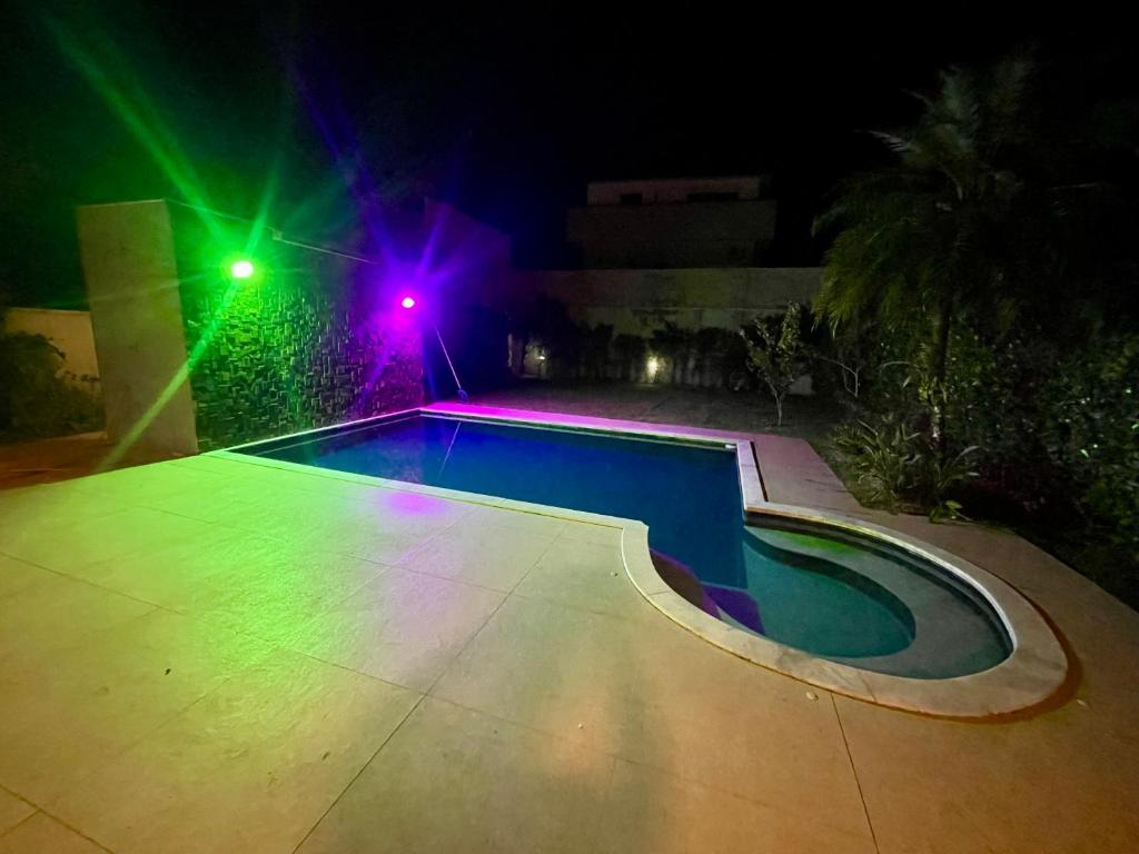 a swimming pool with lights next to a house at Mansão Maretti in Bertioga