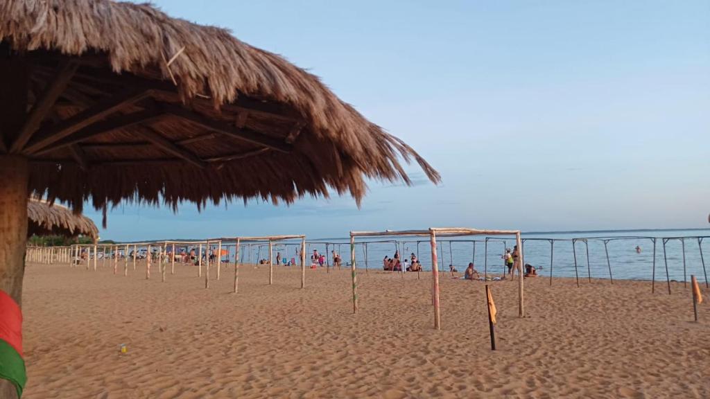 a beach with a bunch of umbrellas and people at Cabaña Alpina Zen in Carmen del Paraná