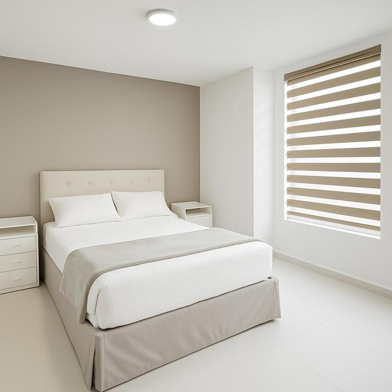 ein weißes Schlafzimmer mit einem großen Bett und einem Fenster in der Unterkunft SextoMaíz in Morelia