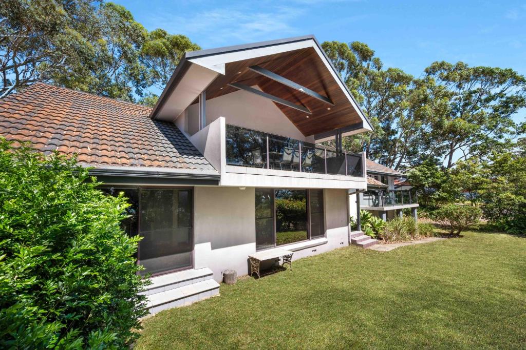 a house with a large window on top of a yard at Amazing Views - Belle Escapes Jervis Bay in Vincentia