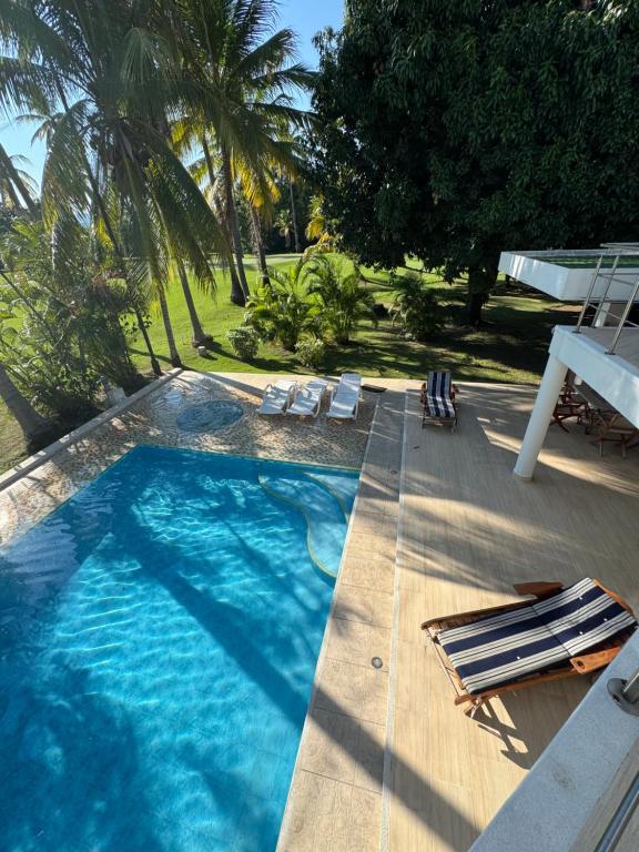 uma grande piscina com cadeiras e palmeiras em Condominio El Peñon, Girardot em El Peñón