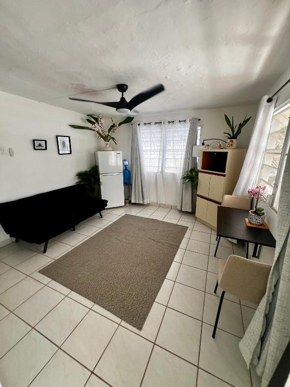 a living room with a couch and a ceiling fan at Beach Hub 7 Mins to Airport in Carolina