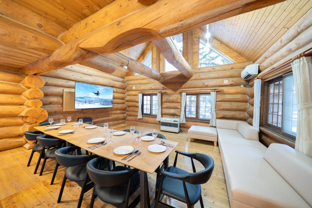 a dining room with a long table and chairs at Terrace Niseko Glide in Kutchan