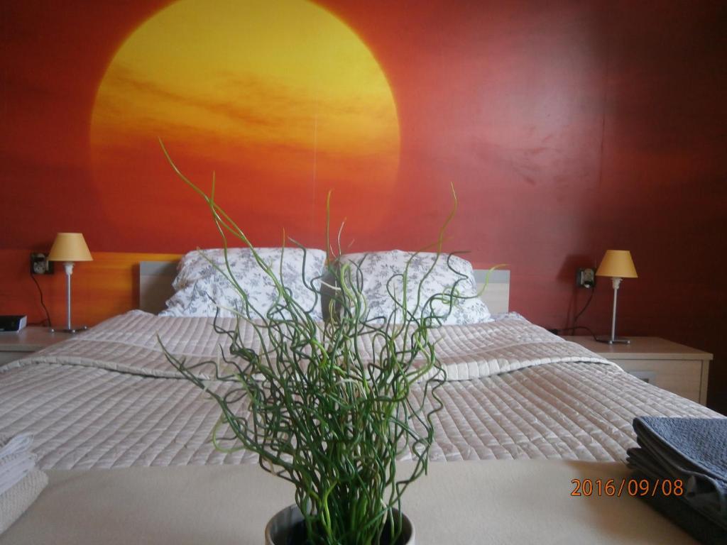 a bedroom with a bed and a vase with a plant at Sloneczna 10tka in Sztutowo