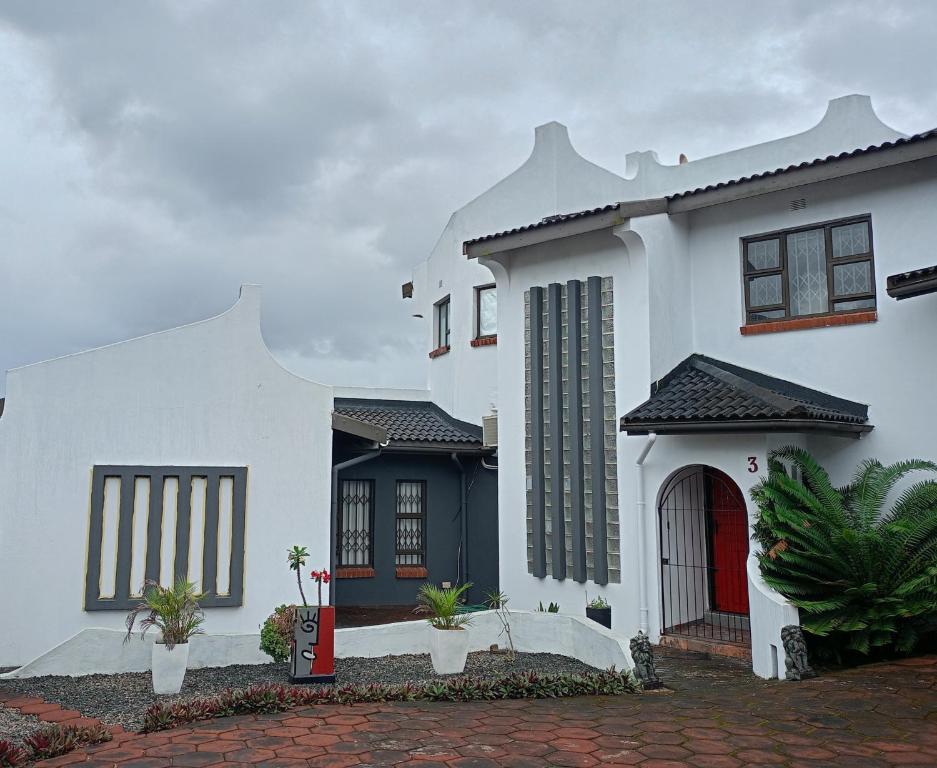 Vanilla Lee Corporate Suite في خليج ريتشاردز: منزل أبيض مع باب احمر