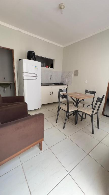 a living room with a table and chairs and a refrigerator at Pousada Atalaia in Cuiabá