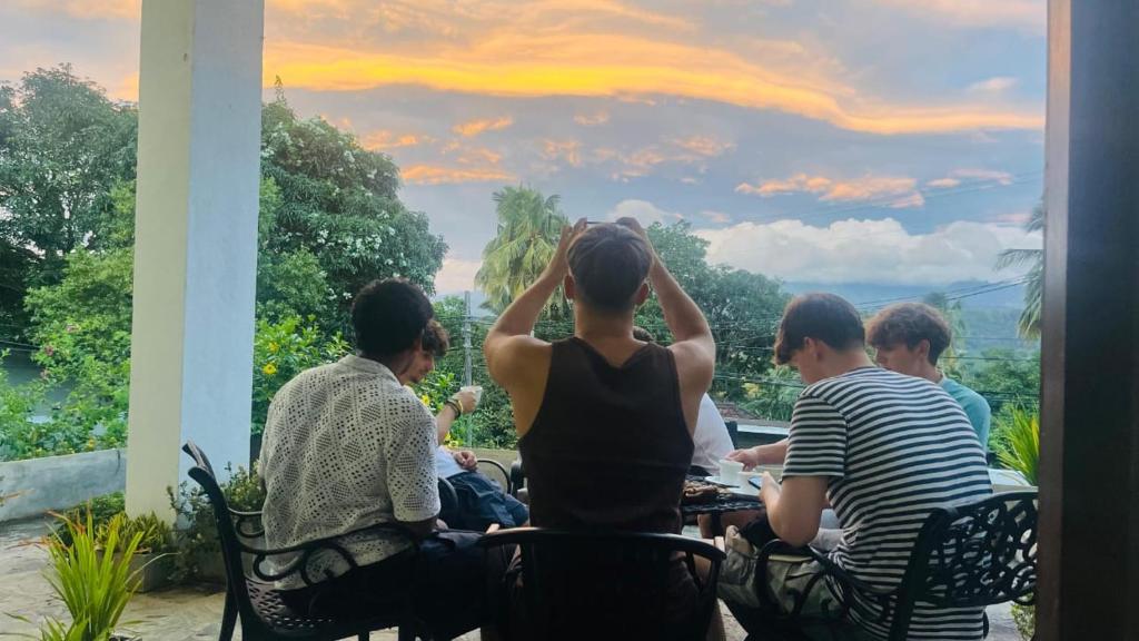 a group of people sitting around a table watching the sunset at The Pinnacle Life in Matale