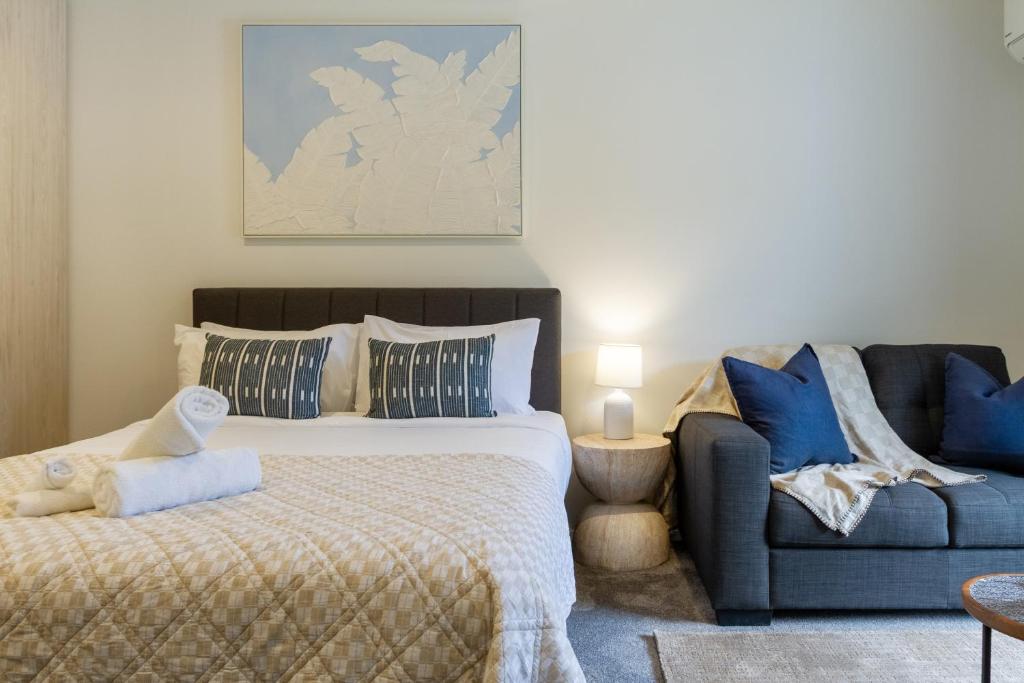 a bedroom with a bed and a couch at Modern Studio Near Stadium, Dining & City Fun in Christchurch