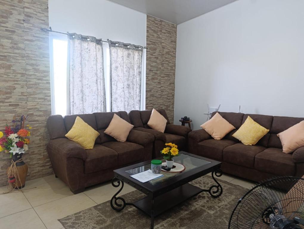 a living room with a couch and a coffee table at Beautiful and cozy home with Rent a car available in San Salvador