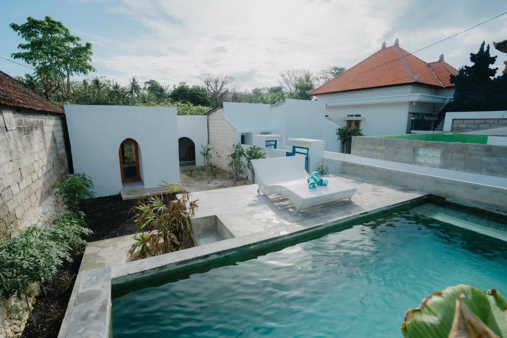 a swimming pool in a yard with a white house at MY BOO PRIVATE by DRAGONFLY in Nusa Penida