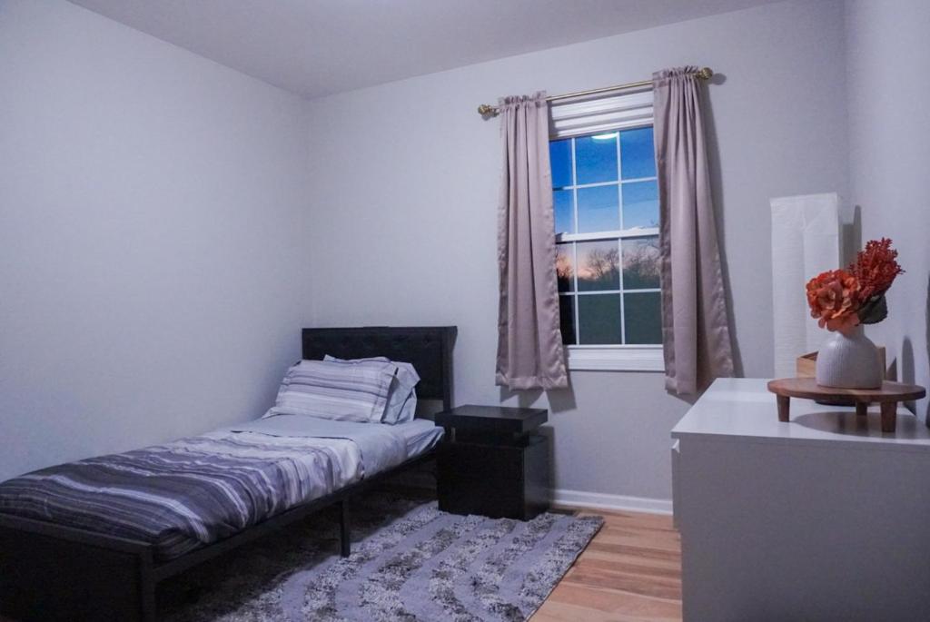 Jacuzzi Cul de Sac Home في Country Club Hills: غرفة نوم بها سرير ونافذة