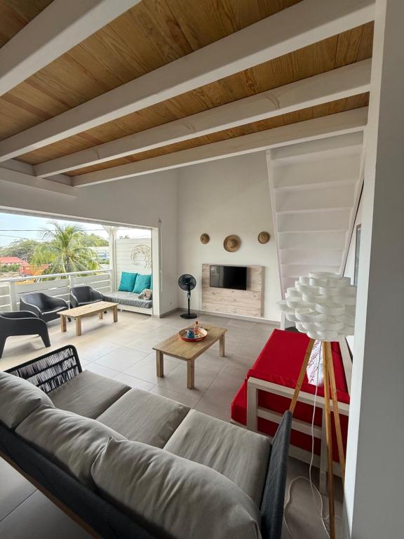 a living room with a couch and a table at Appartement neuf a 150 metres de la mer wifi in Le Diamant