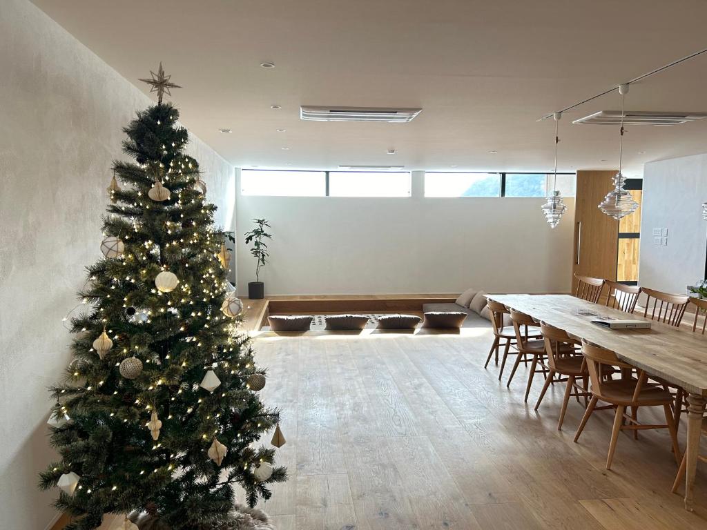 a christmas tree in a room with a table and chairs at Private luxury villa with ocean view Shodoshima in Shodoshima