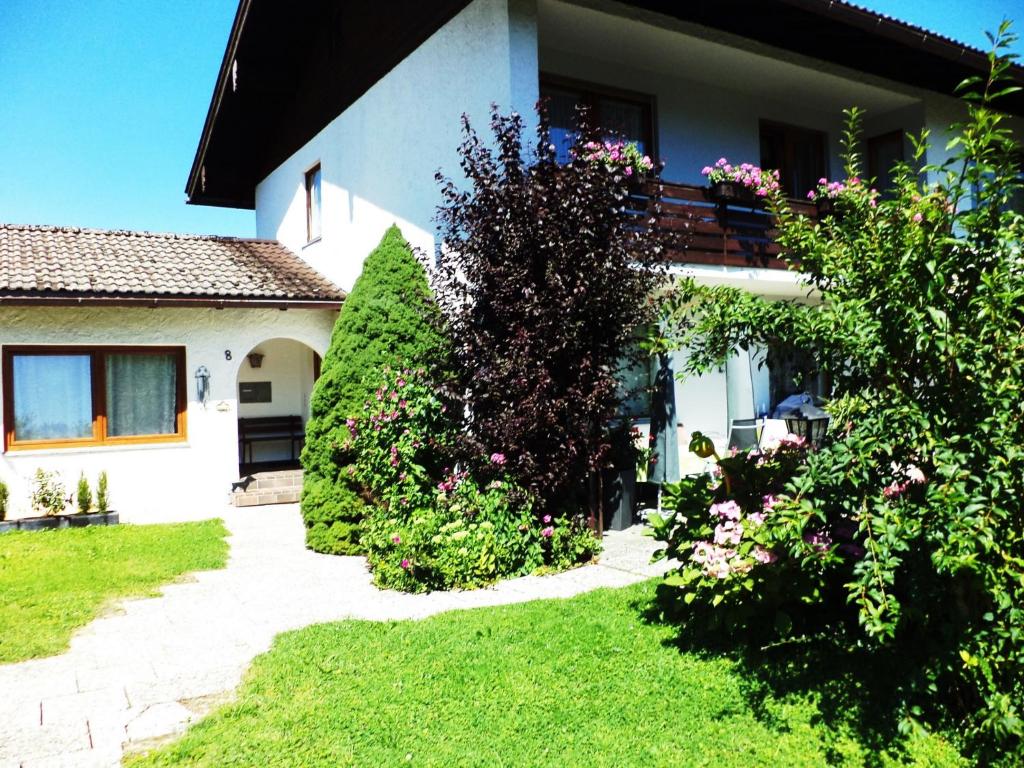 ein Haus mit Büschen und Blumen im Hof in der Unterkunft Haus Elisabeth in Marquartstein