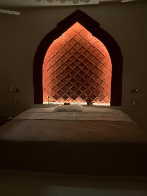 a bed in a room with a lit up window at Bellerive in Kilifi