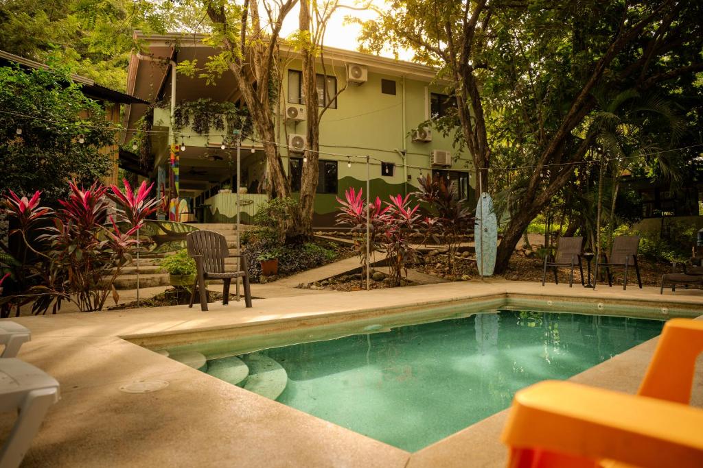 a small swimming pool in front of a house at Casa Pura Vida Surf Hostel - Tamarindo Costa Rica in Tamarindo