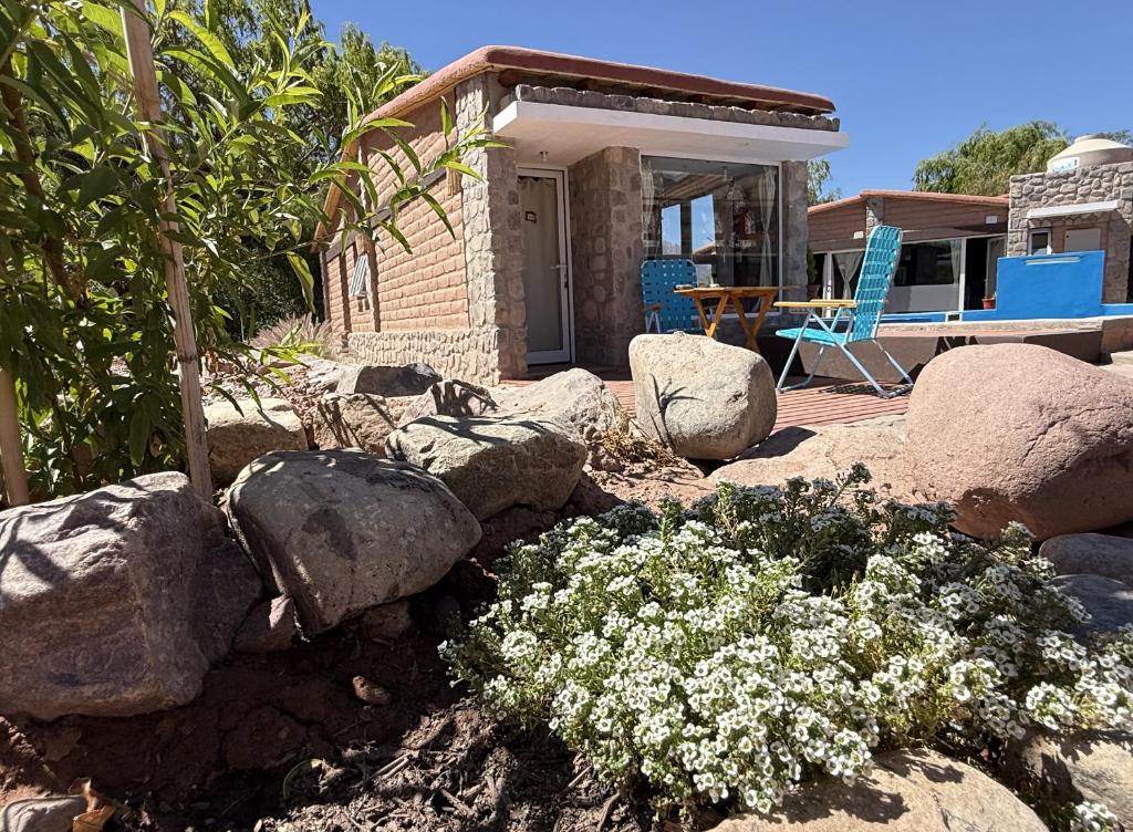 een tuin met rotsen en bloemen voor een huis bij Cabañas Los Cardones Tilcara in Tilcara
