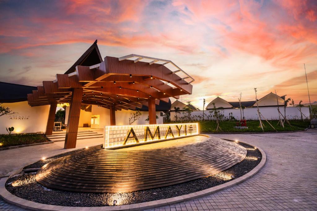 a large fountain in front of a building with a sign at Amayi Resort Nusa Dua in Nusa Dua