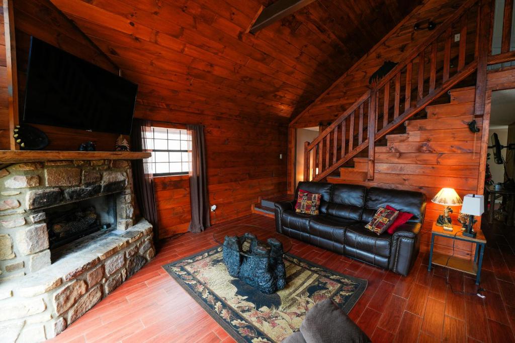 a living room with a couch and a fireplace at The Bearfoot Cabin! Ideally located, decorated for Christmas, Fireplace, Game Room! in Sevierville