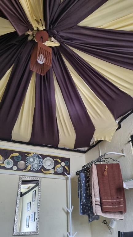 een podium met paarse en gele gordijnen en een spiegel bij GNOME KIT HOUSE São Tomé das Letras- Mg in São Thomé das Letras