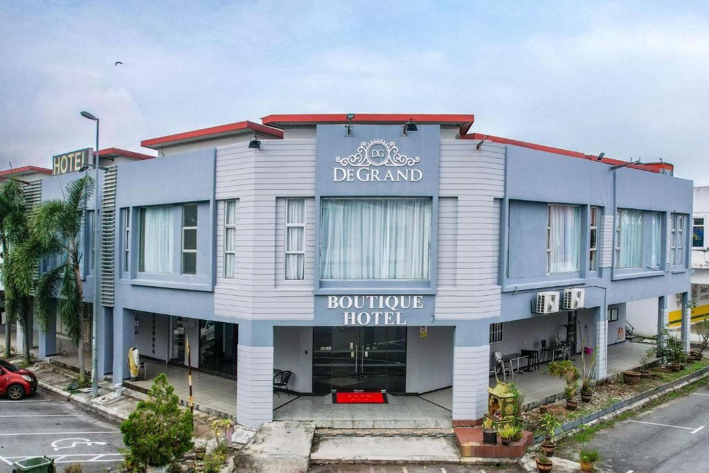 a blue and white building with a sign on it at De Grand Boutique Hotel in Sepang