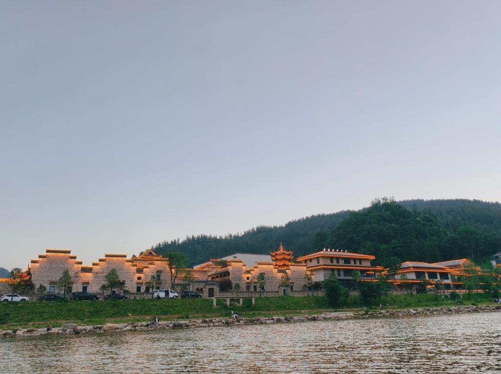 a group of houses next to a body of water at 张家界武陵源山边溪上客栈-About a 10-minute walk from the east gate of the Forest Park - there is a beautiful little river at the entrance - free recommended travel routes provided - Tickets for attractions can be booked in advance in Zhangjiajie