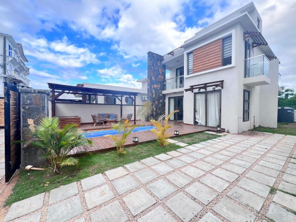 Villa Unique في غراند بايَ: اطلالة خارجية على منزل مع فناء