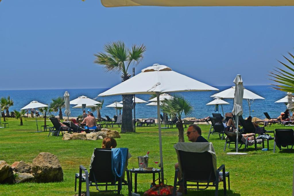 a group of people sitting in lawn chairs under an umbrella at Amphora Hotel & Suites in Paphos