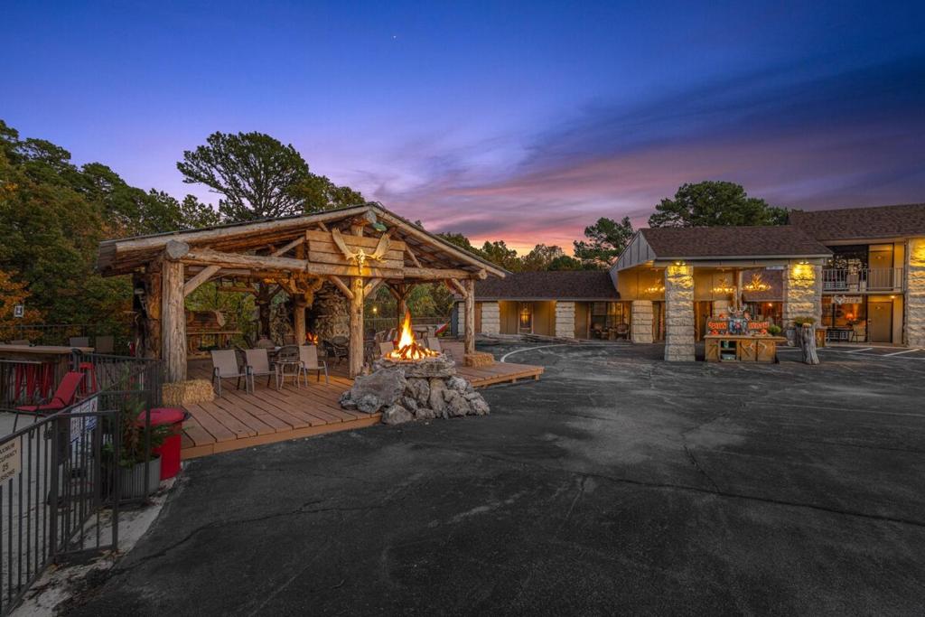 Una casa con una gran terraza con fogata. en Stonegate Lodge Salt Water Pool2 Queen Beds Fire Pits Fast WiFi Room #205, en Eureka Springs