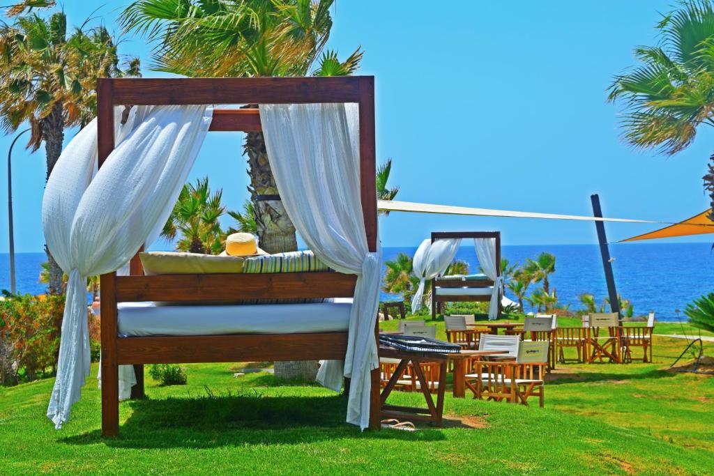 a canopy bed at a resort with a view of the ocean at Amphora Hotel & Suites in Paphos