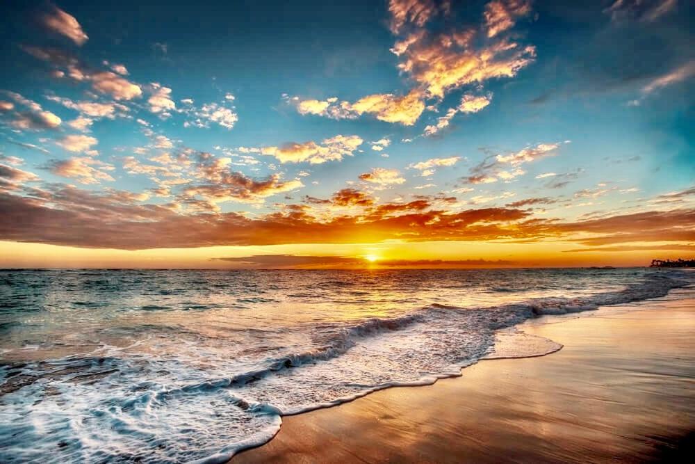 een zonsondergang boven een strand met de oceaan bij Beachfront HouseSteps to Sand Sunset in Indian Rocks Beach