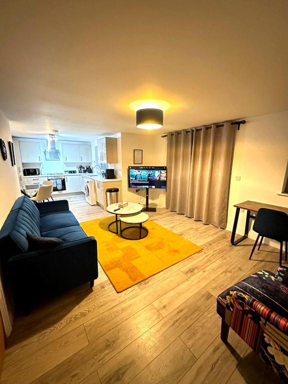 een woonkamer met een bank en een tafel bij Modern Ground floor 2 Bed Room Apartment Work Leisure Free Parking in Woking