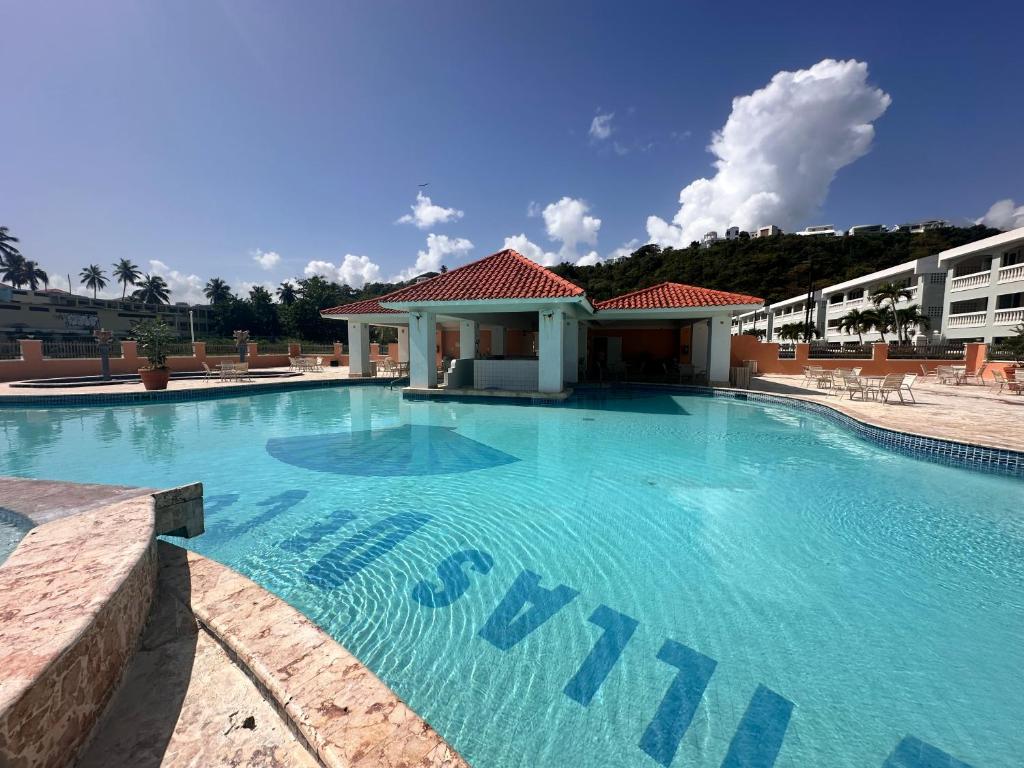a large swimming pool in front of a building at Verano Azul Beachfront Apartment in Isabela in Isabela